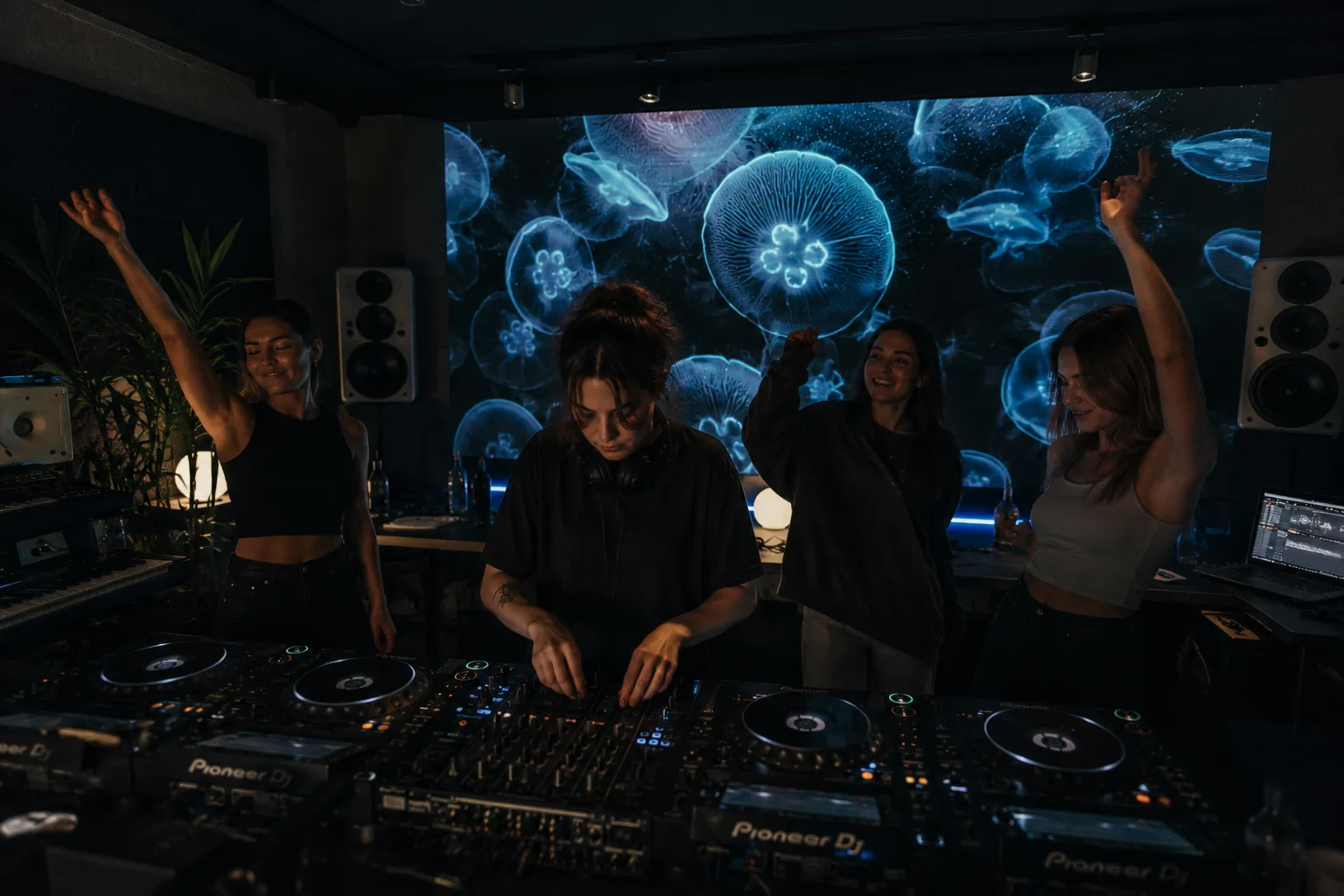 DJ performing with an OOVIE jellyfish visual on the screen behind the booth